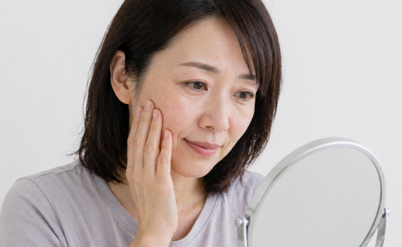顔のしわ・たるみを気にして鏡を見る女性