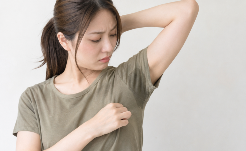 Tシャツにできた汗ジミを気にしている女性