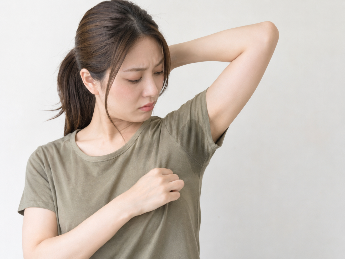 Tシャツにできた汗ジミを気にしている女性