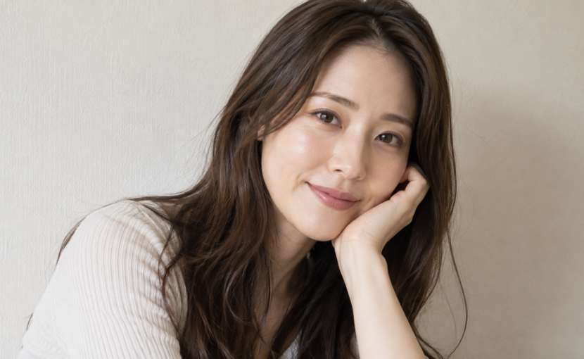 肘をついて微笑む女性