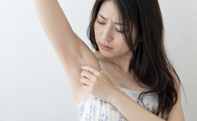 自分の脇を見ている女性