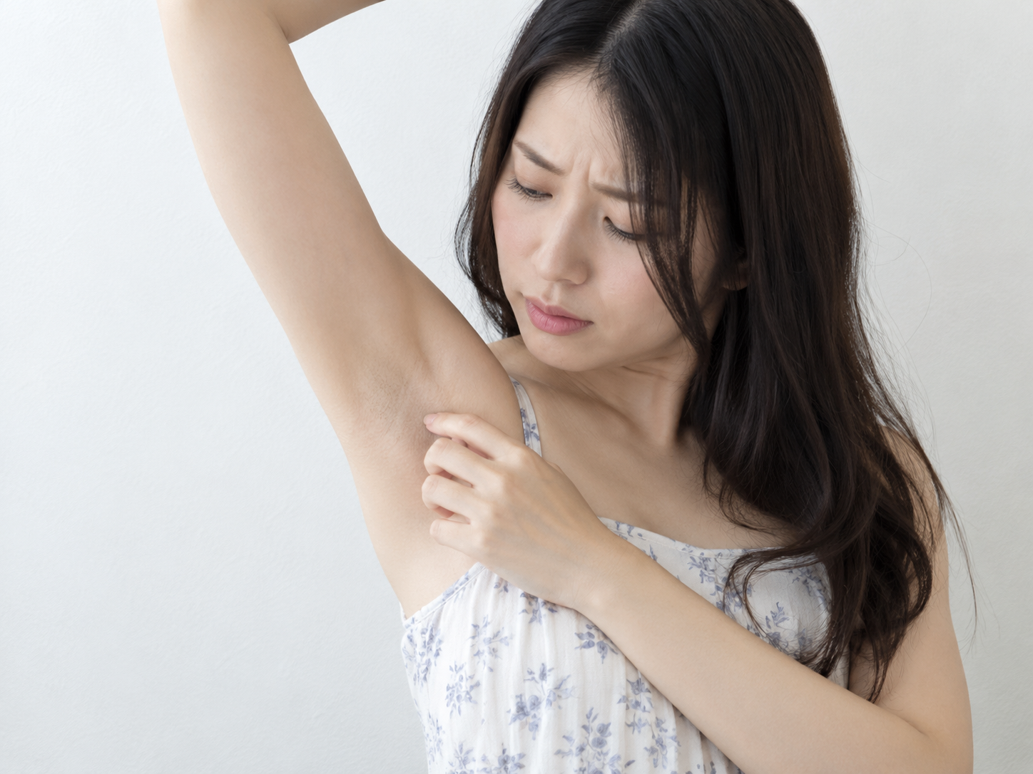 自分の脇を見ている女性