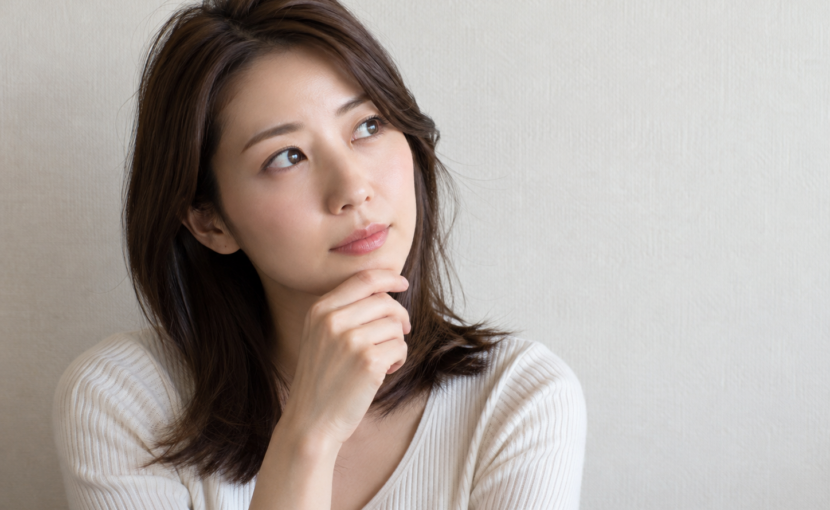 顎に手を当てて考える女性